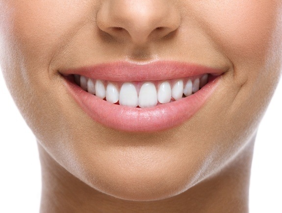 Close up of a person with straight white teeth grinning