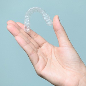 Closeup of patient holding clear aligner