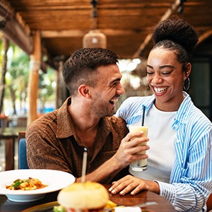 Couple smiling while enjoying meal at restaurant