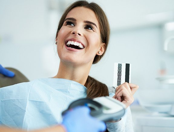 A woman paying her dentist with a credit card
