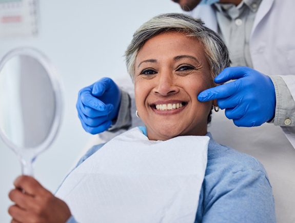 a patient smiling while visiting her dentist