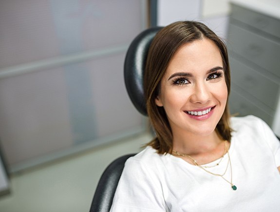 A beautiful, smiling woman sitting in a dentist’s chair