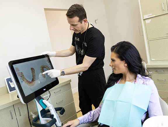 Doctor Magid showing a patient digital images of their teeth on computer screen