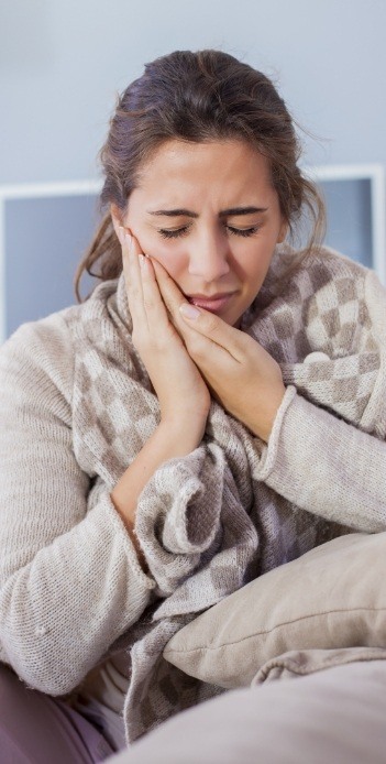 Woman holding her cheek in pain