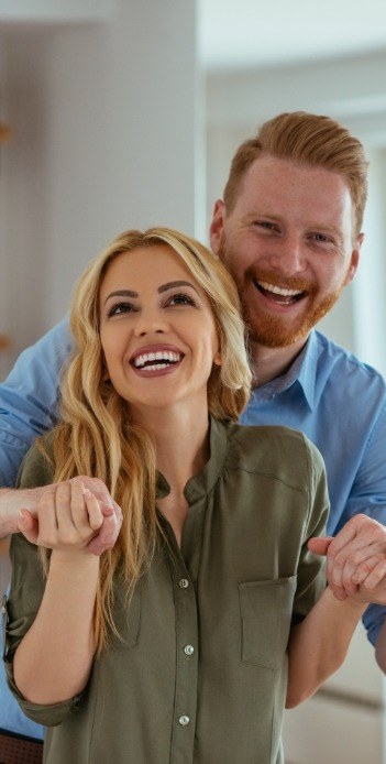 Smiling man and woman holding hands in their house