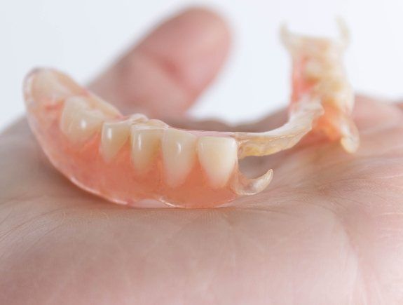 Person holding a partial denture in West Caldwell in their hand