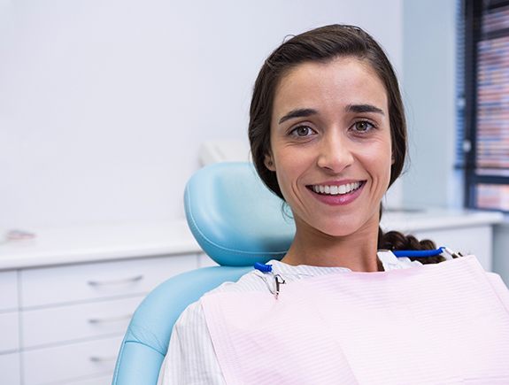 Woman sitting in dental chair and smiling