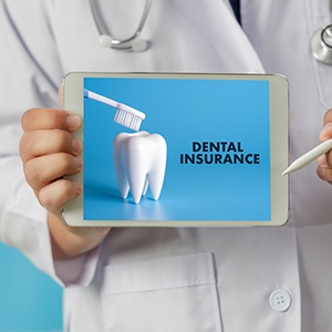 Dentist holding tablet with the words dental insurance