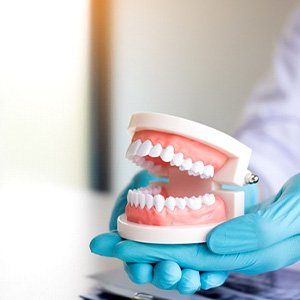 dentist holding false teeth