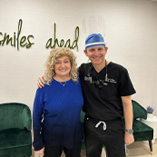 Doctor Magid smiling with his arm around dental patient