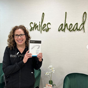 Dental team member holding a box of Invisalign clear aligners