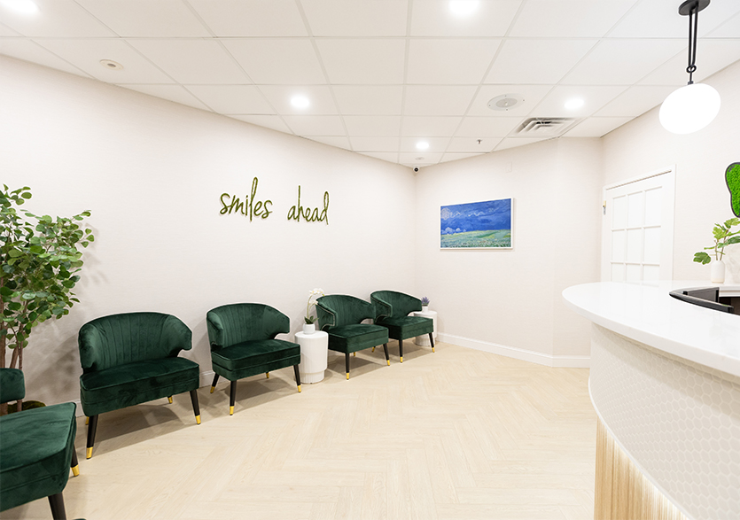 Dental office waiting room with sign on wall saying smiles ahead