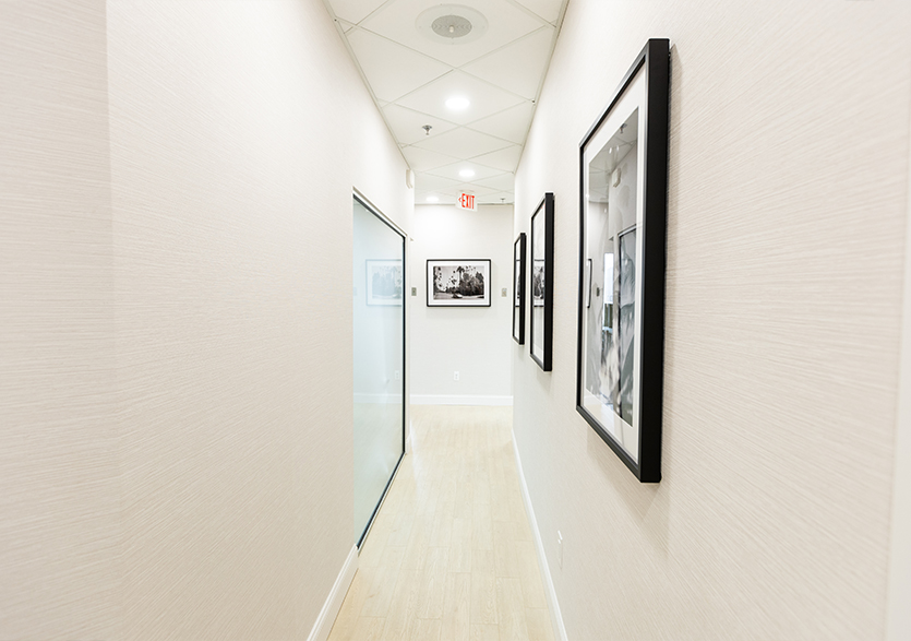 Hallway in dental office with several framed photos on wall