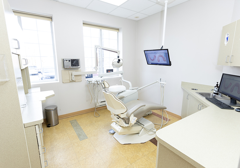 Dental exam room with digital models of teeth on computer monitors