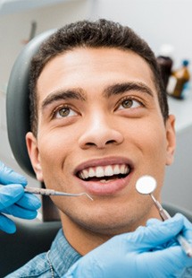 man smiling while visiting dentist 