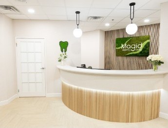 patients smiling at receptionist desk in West Caldwell