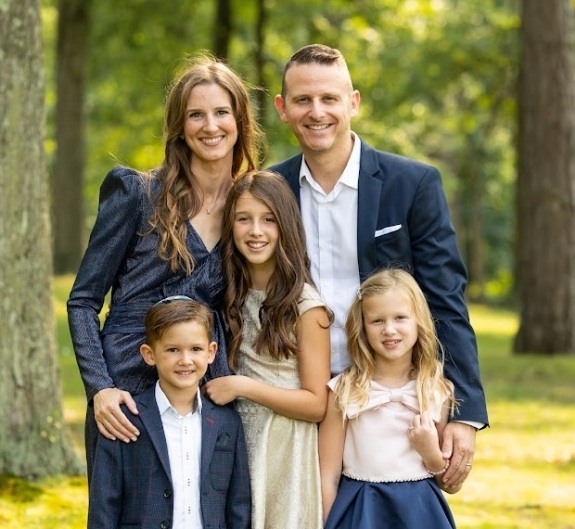 Doctor Magid smiling outdoors with his family