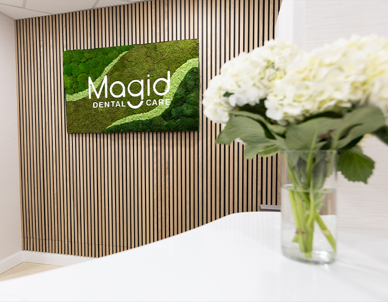 White flowers in vase on front desk at Magid Dental Care