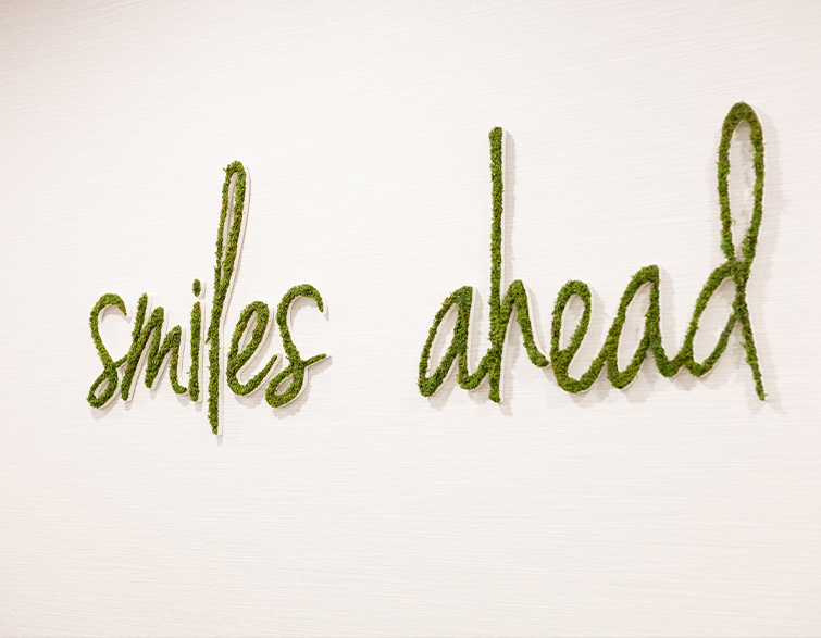The words Smiles Ahead on a wall in moss green
