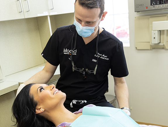 Doctor Magid talking to a patient during a dental checkup in West Caldwell