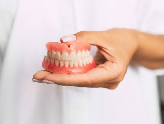 Dentist holding a set of dentures