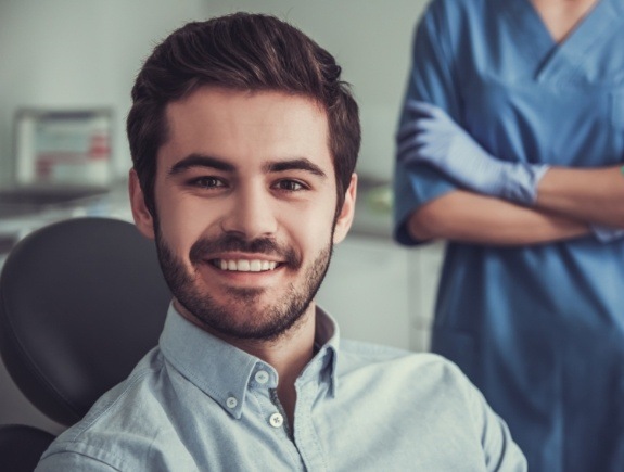 Man in dental chair smiling after root canal treatment in West Caldwell