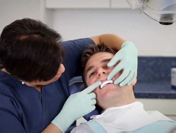 Dentist fitting a patient with an oral appliance for sleep apnea treatment in West Caldwell