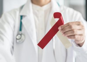 a dentist holding an oral cancer awareness month ribbon