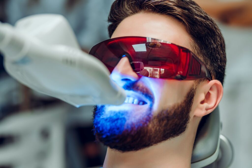 A man getting his teeth whitened at the dentist
